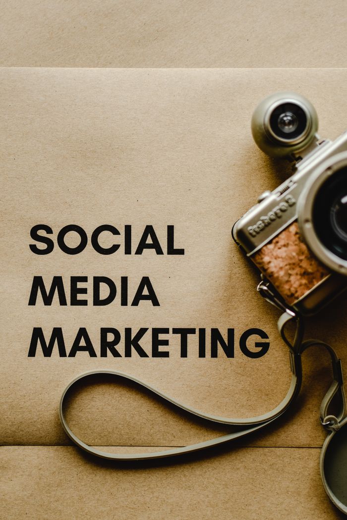 about-us-01 Close-up of a vintage camera next to a social media marketing concept text on a brown background.